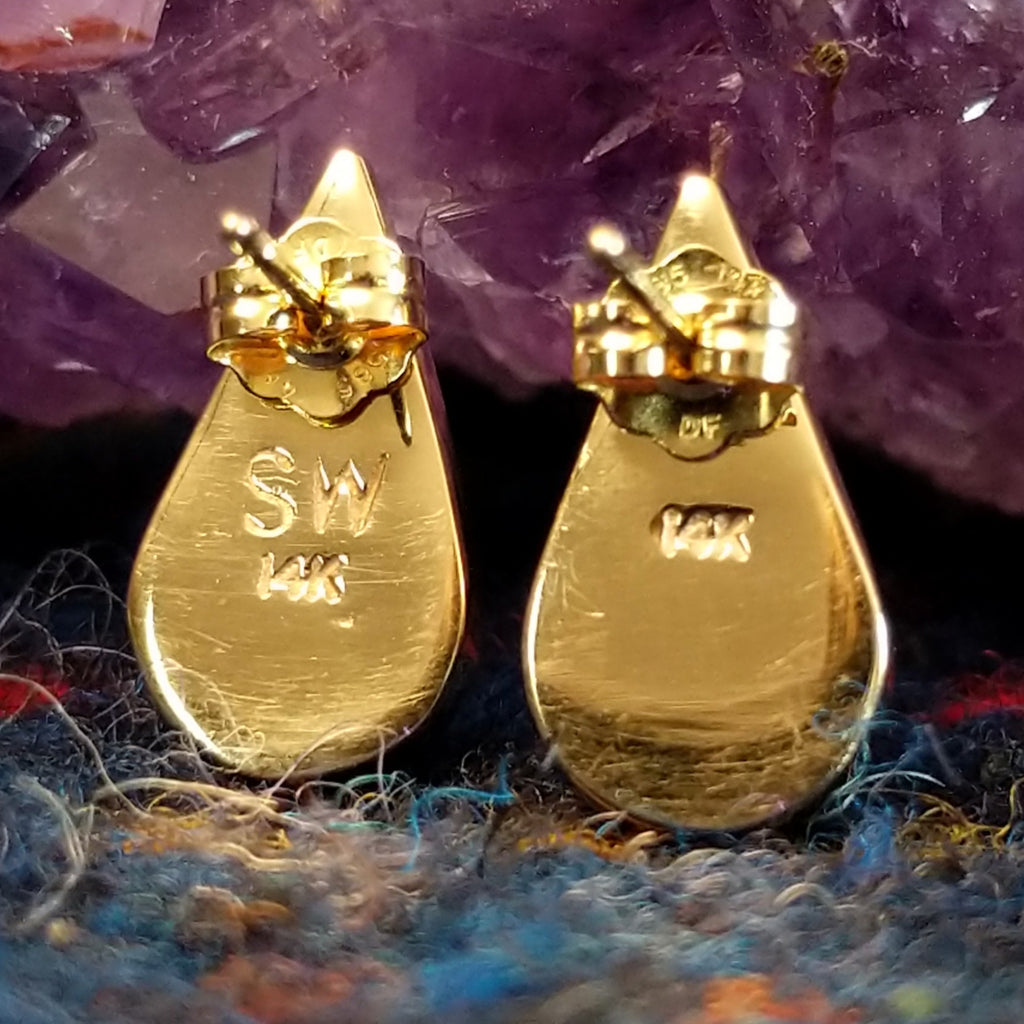 The artist's signature and gold stamp is visible on the back of the earrings.