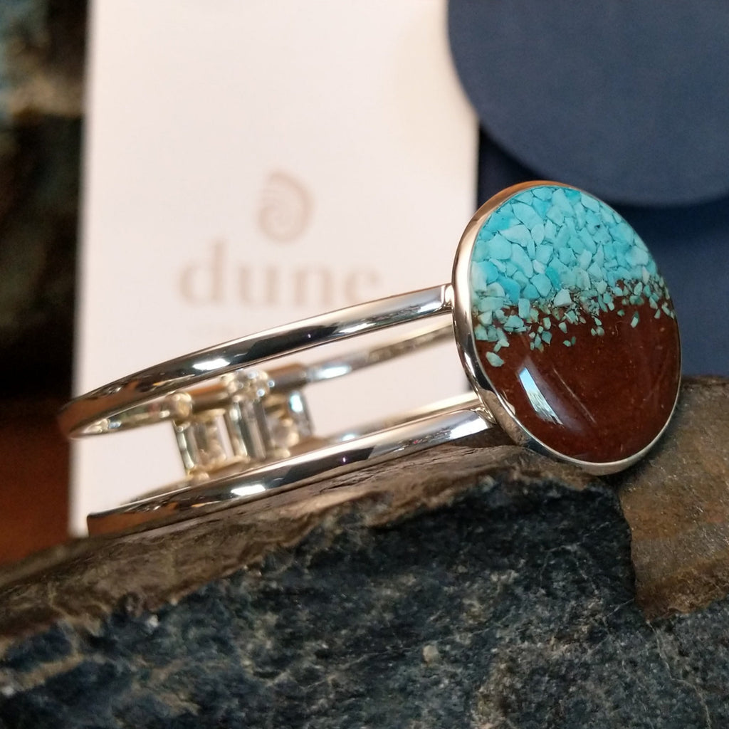 Turquoise and Lake Powell sand set in the large circular bezel of the cuff bracelet.