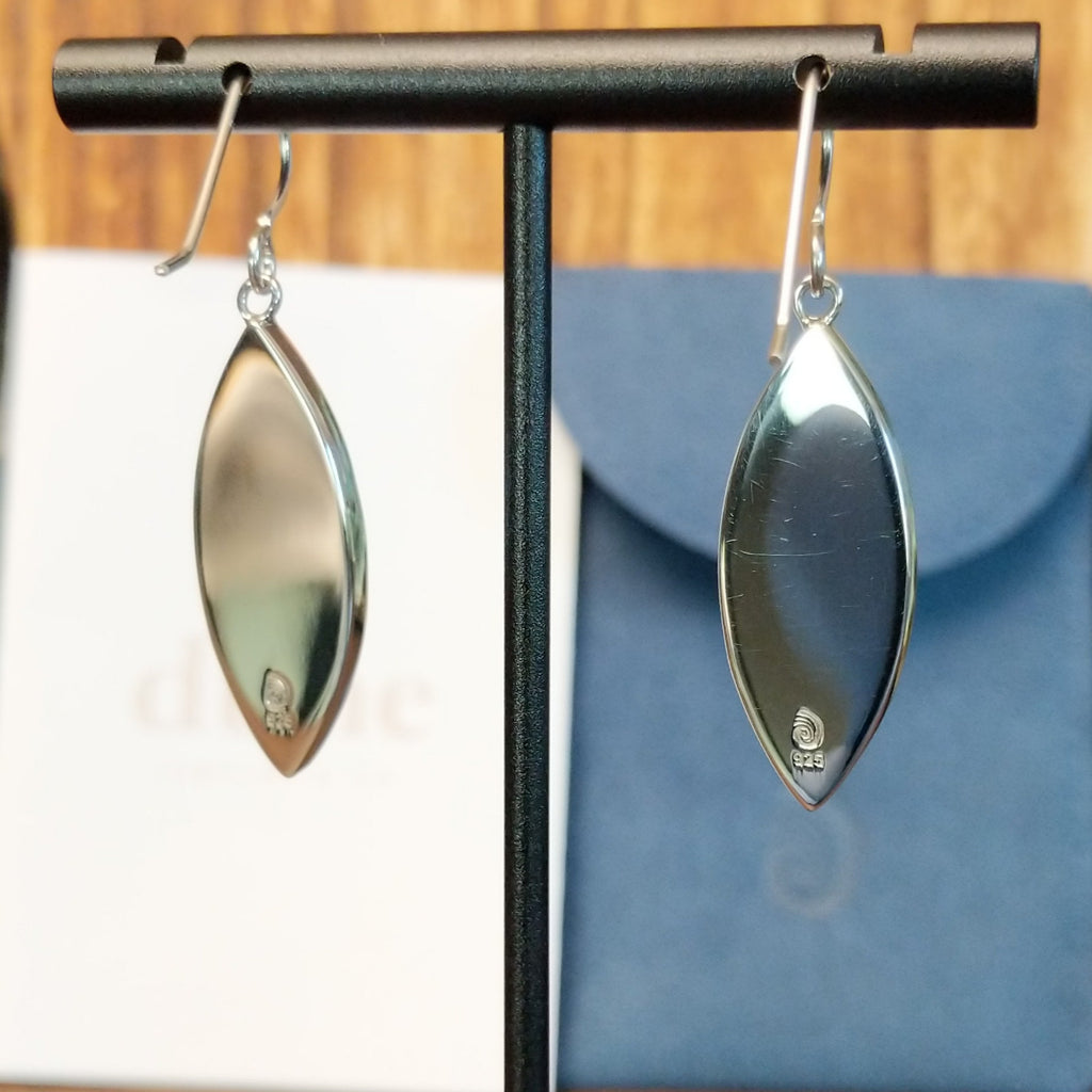 The back of the earrings feature the silver authentication and trademark.