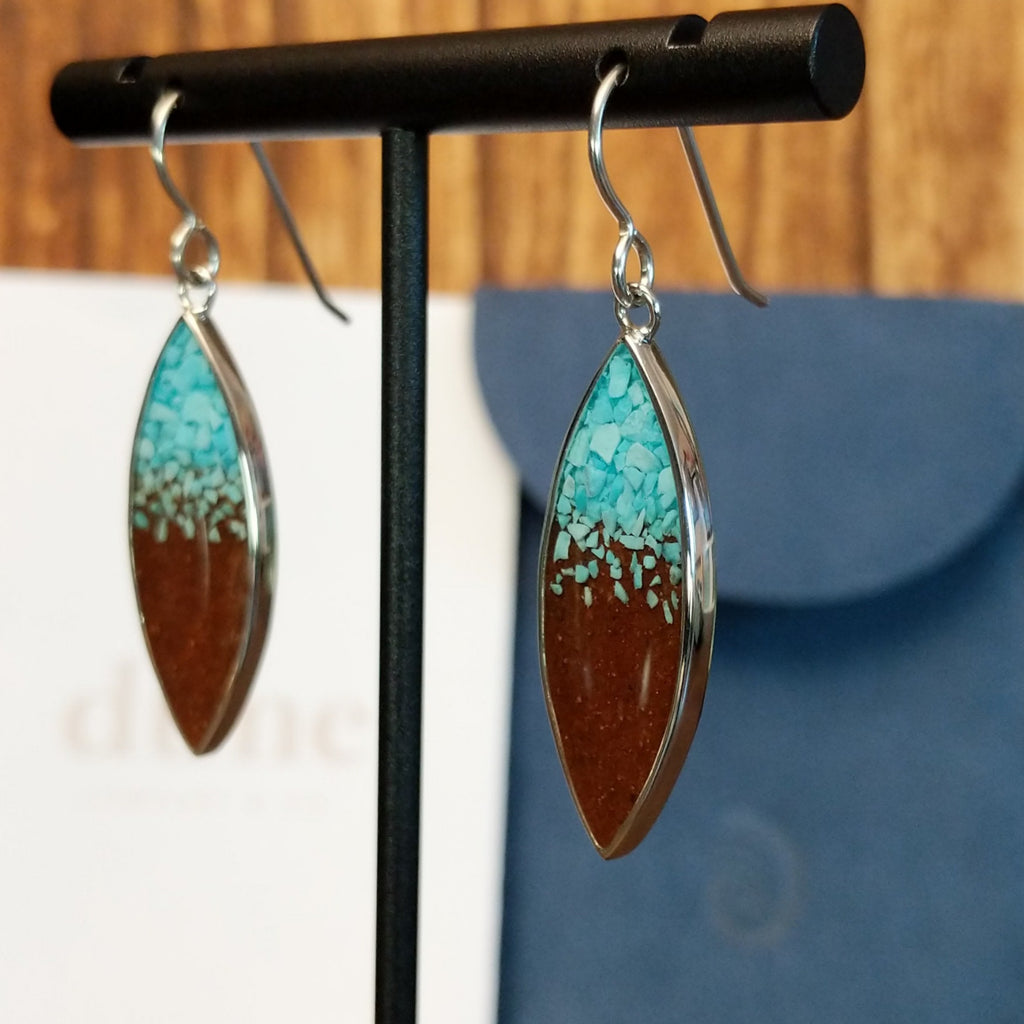Turquoise and Lake Powell sand set in sterling silver bezels on the dangle earrings.