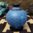 Blue Mata Ortiz pottery vase with a flared black neck, featuring intricate geometric patterns of small black squares and red accent details near the rim.