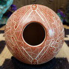 Round Mata Ortiz pottery vessel featuring an etched butterfly design in warm clay tones with intricate geometric linework across the surface.