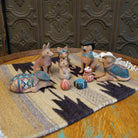 Clay sculpted into individual coyote pieces that form a nativity scene and are painted in various, colorful designs.