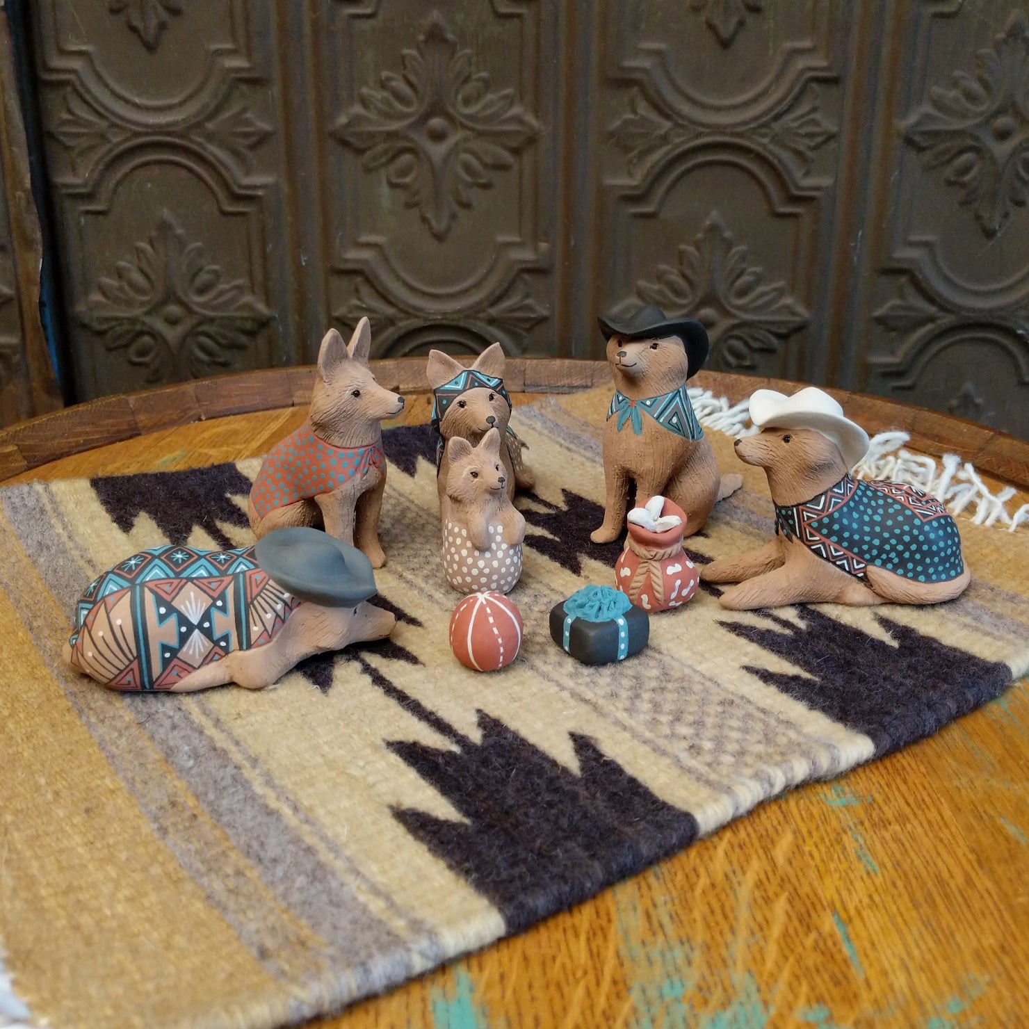 Clay sculpted into individual coyote pieces that form a nativity scene and are painted in various, colorful designs.