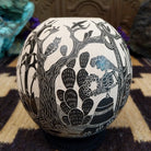 Round Mata Ortiz pottery vessel featuring an etched black and white Day of the Dead scene. 