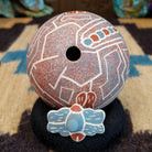 Round lidded Mata Ortiz pottery vessel featuring a dragonfly design in blue and clay tones with etched geometric background patterns.
