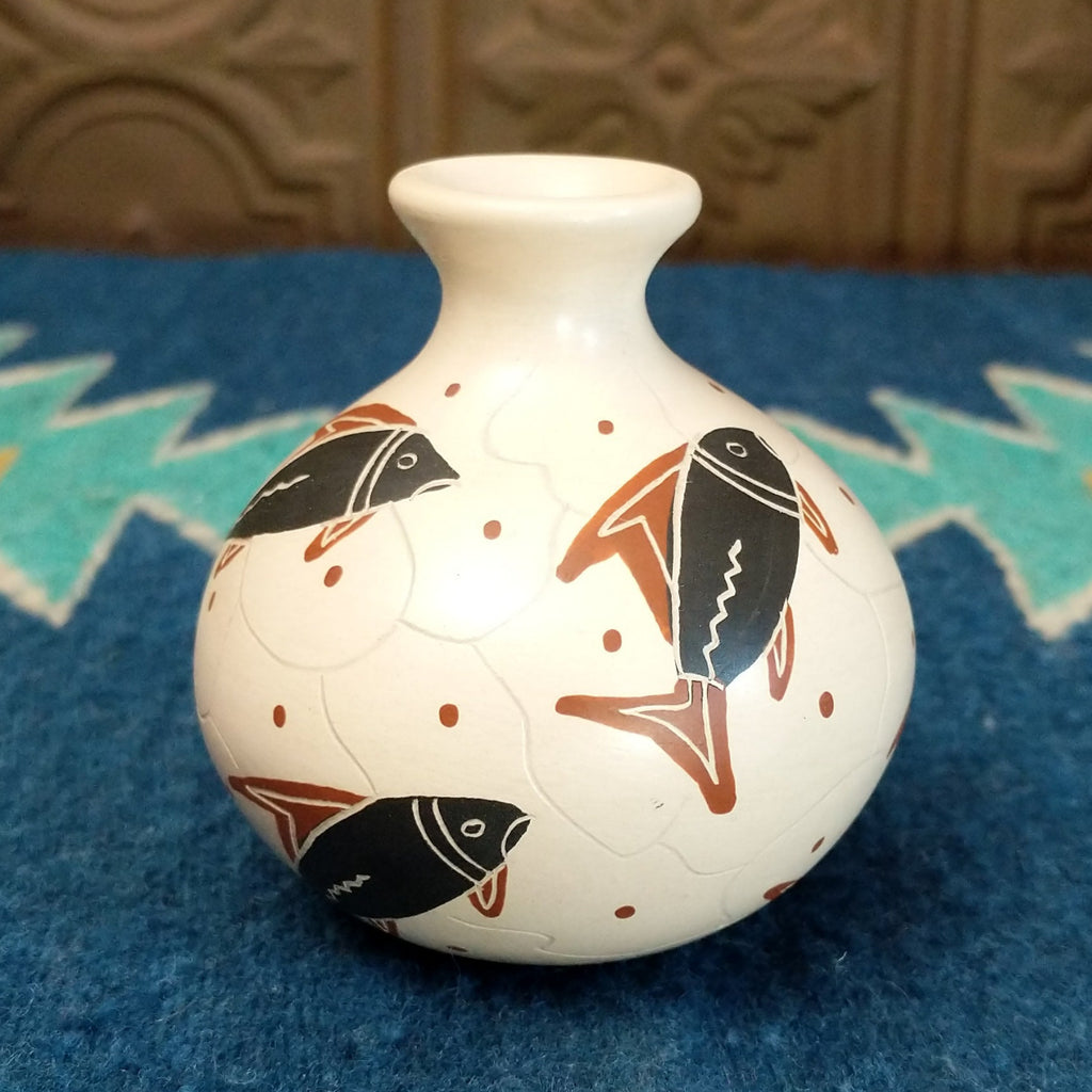 White clay vase with traditionally colored fish designs on the surface.