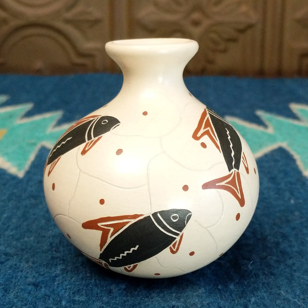 White clay vase with traditionally colored fish designs on the surface.