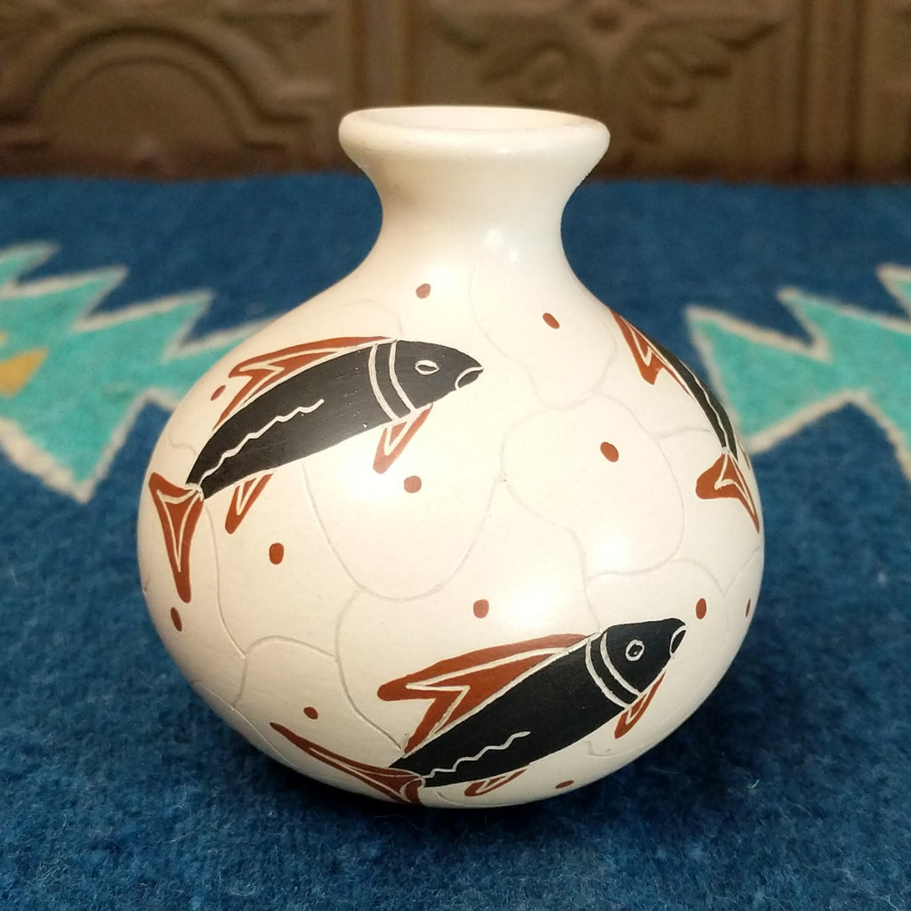 White clay vase with traditionally colored fish designs on the surface.