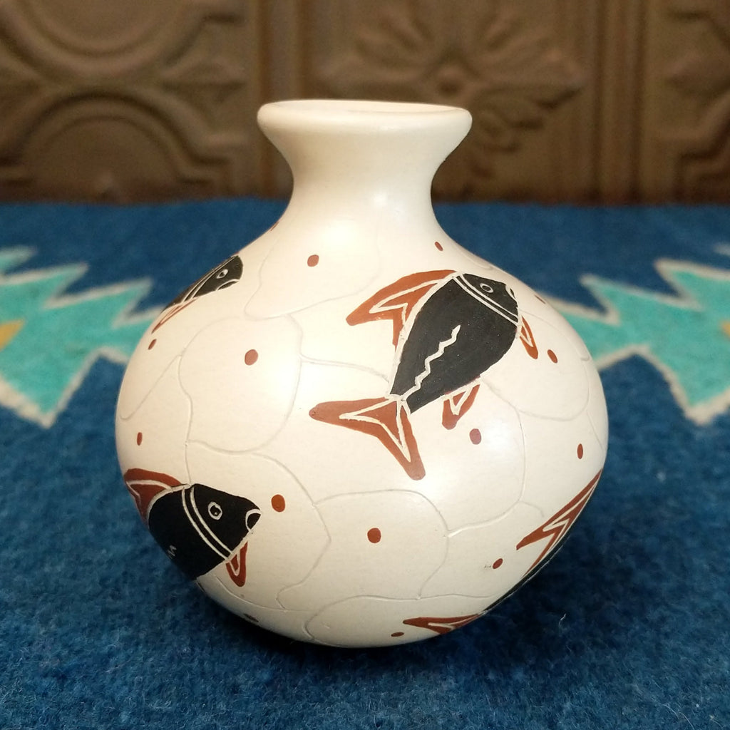 White clay vase with traditionally colored fish designs on the surface.