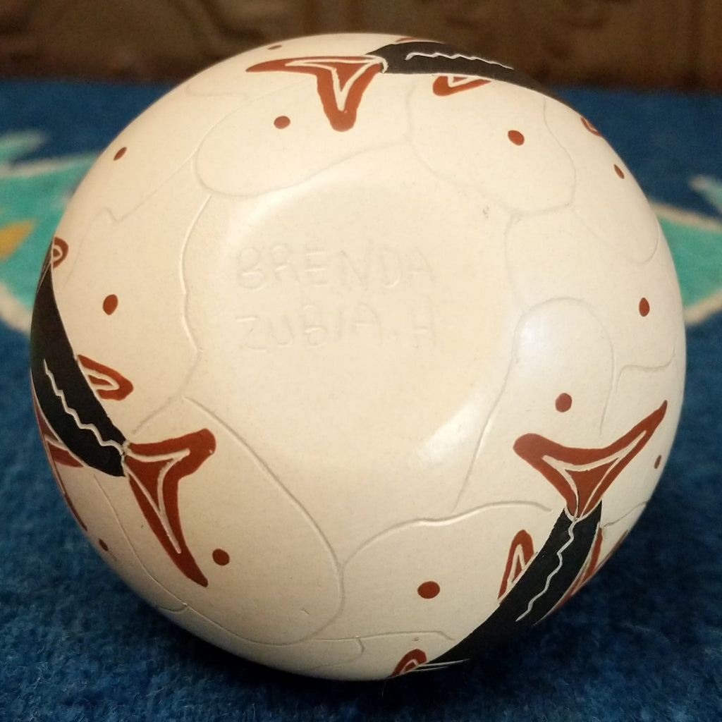 The underside of the pot features the artisan's signature.