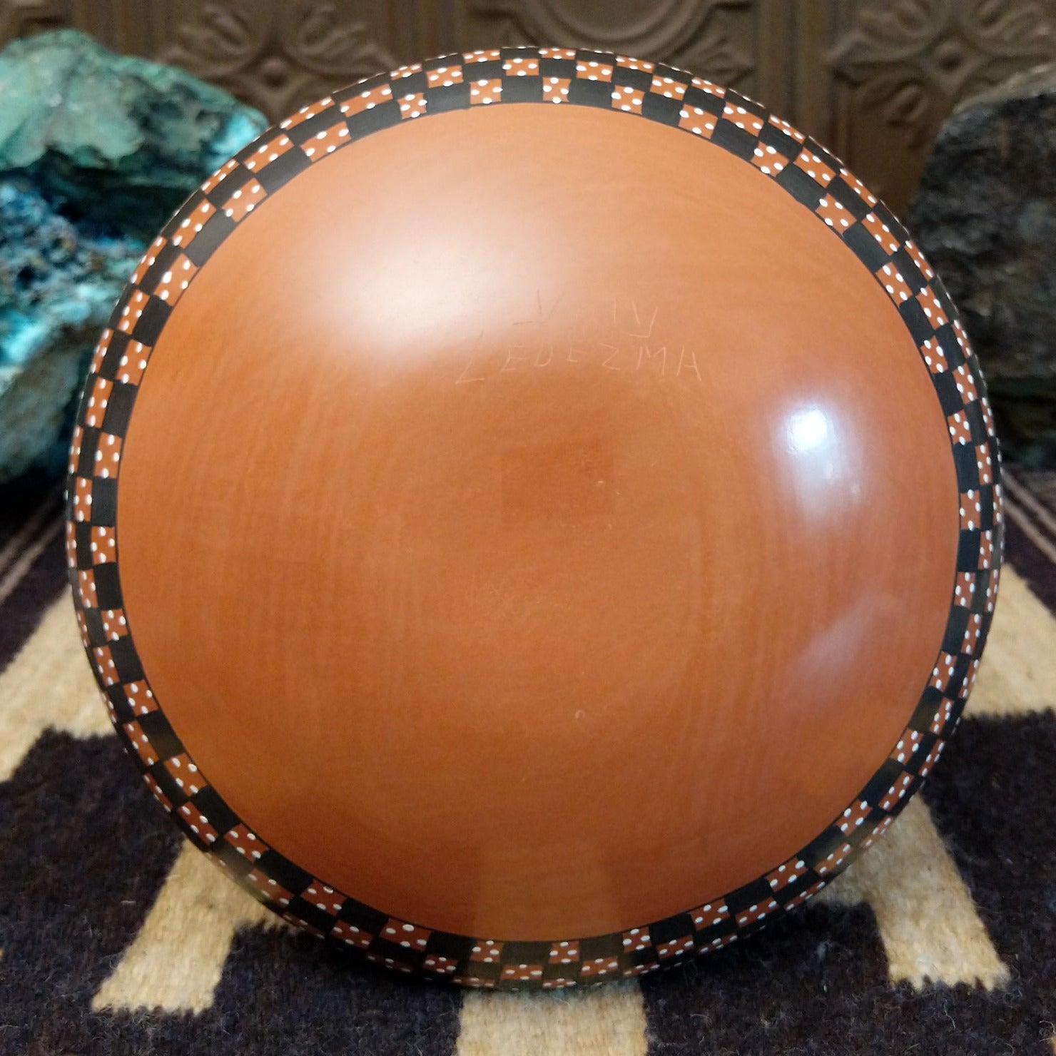 Low-profile Mata Ortiz pottery jar with a geometric checkerboard pattern in black and clay tones, featuring white dotted accents and a squared neck opening.