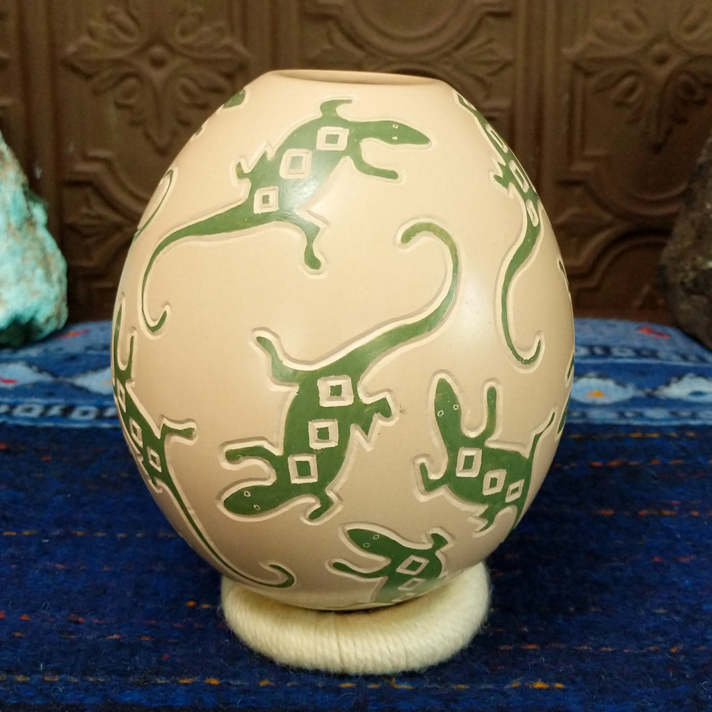 White clay base with green lizard motifs all along it.