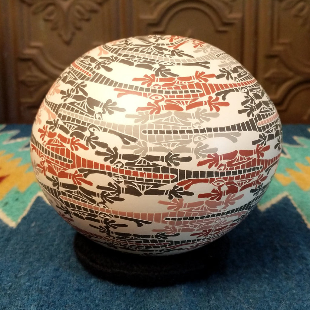 White clay with traditionally painted lizard motifs along the surface.