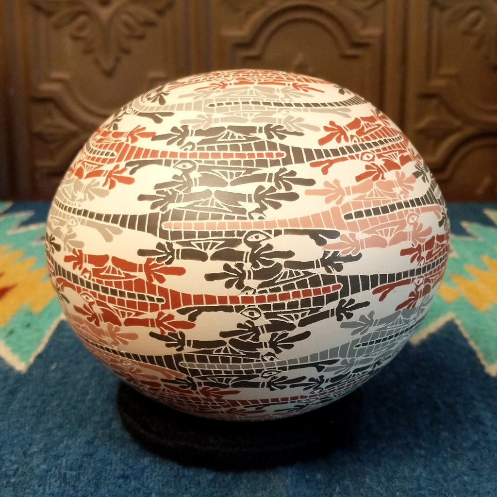 White clay with traditionally painted lizard motifs along the surface.