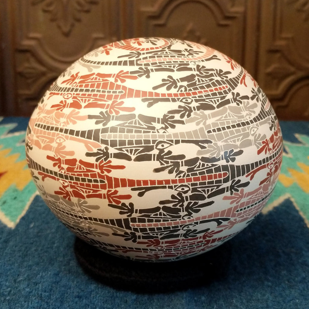 White clay with traditionally painted lizard motifs along the surface.