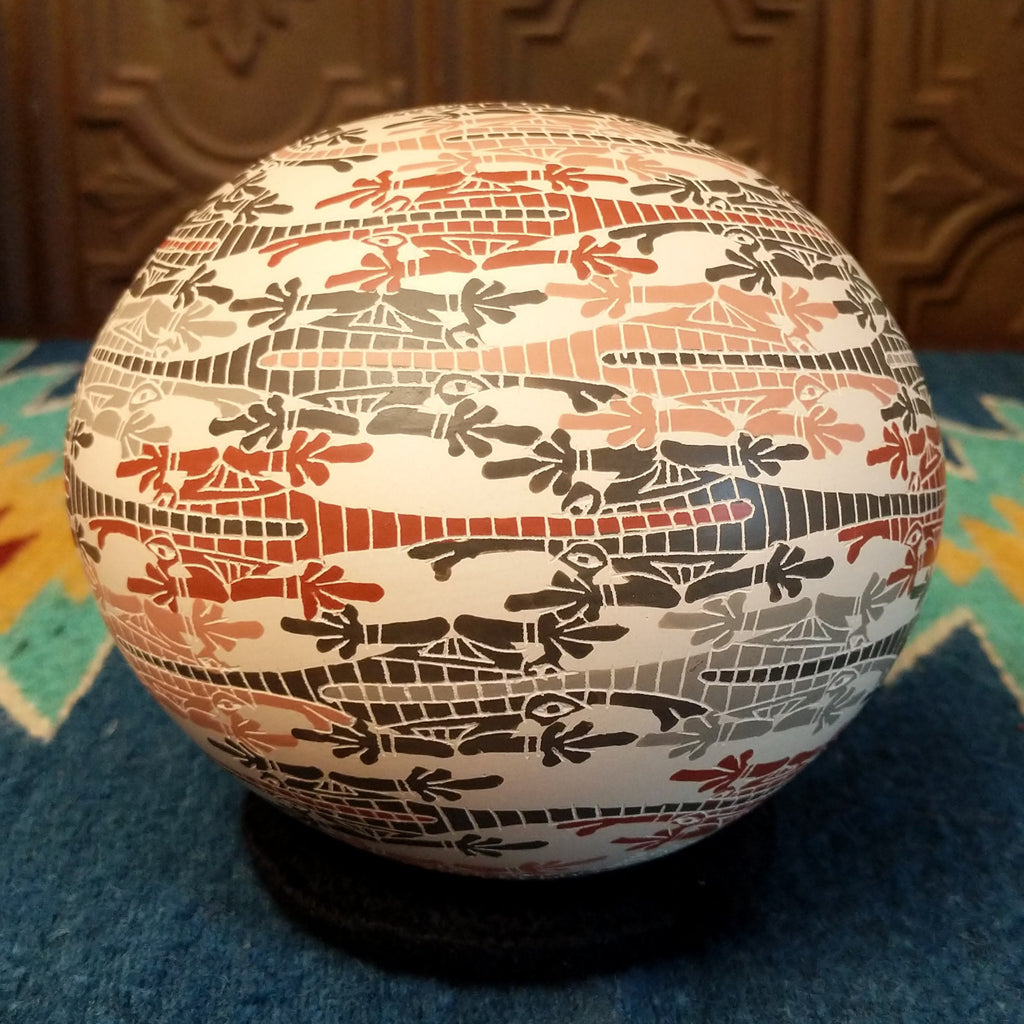 White clay with traditionally painted lizard motifs along the surface.