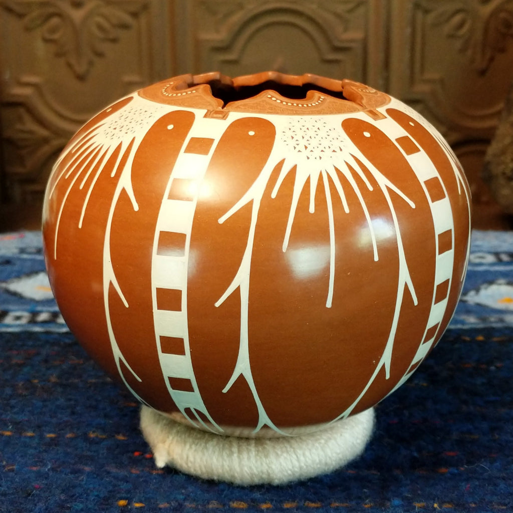 White clay and terracotta pot with intricate designs.