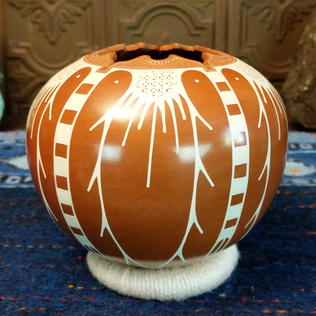 White clay and terracotta pot with intricate designs.