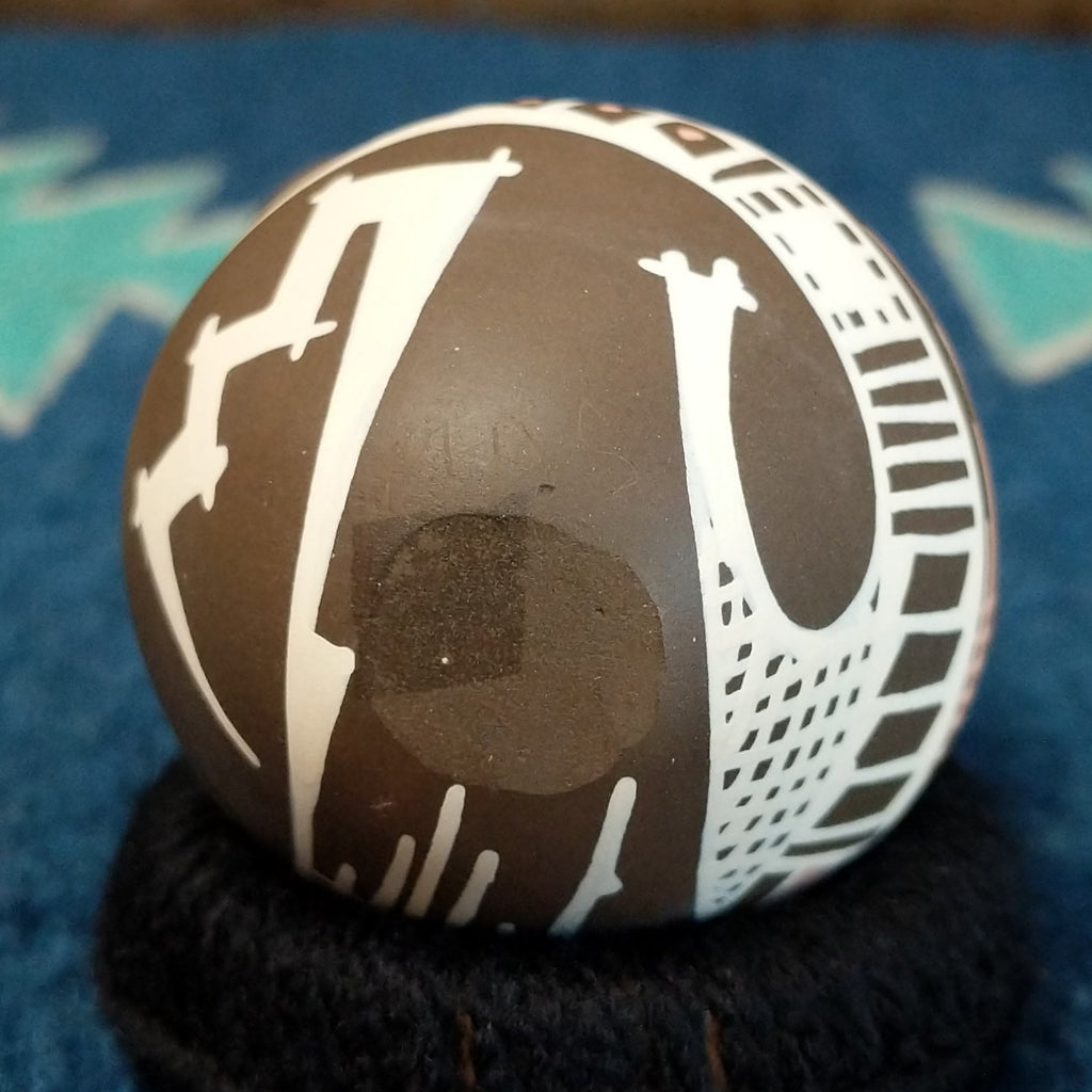 The underside of the pot features the initials.