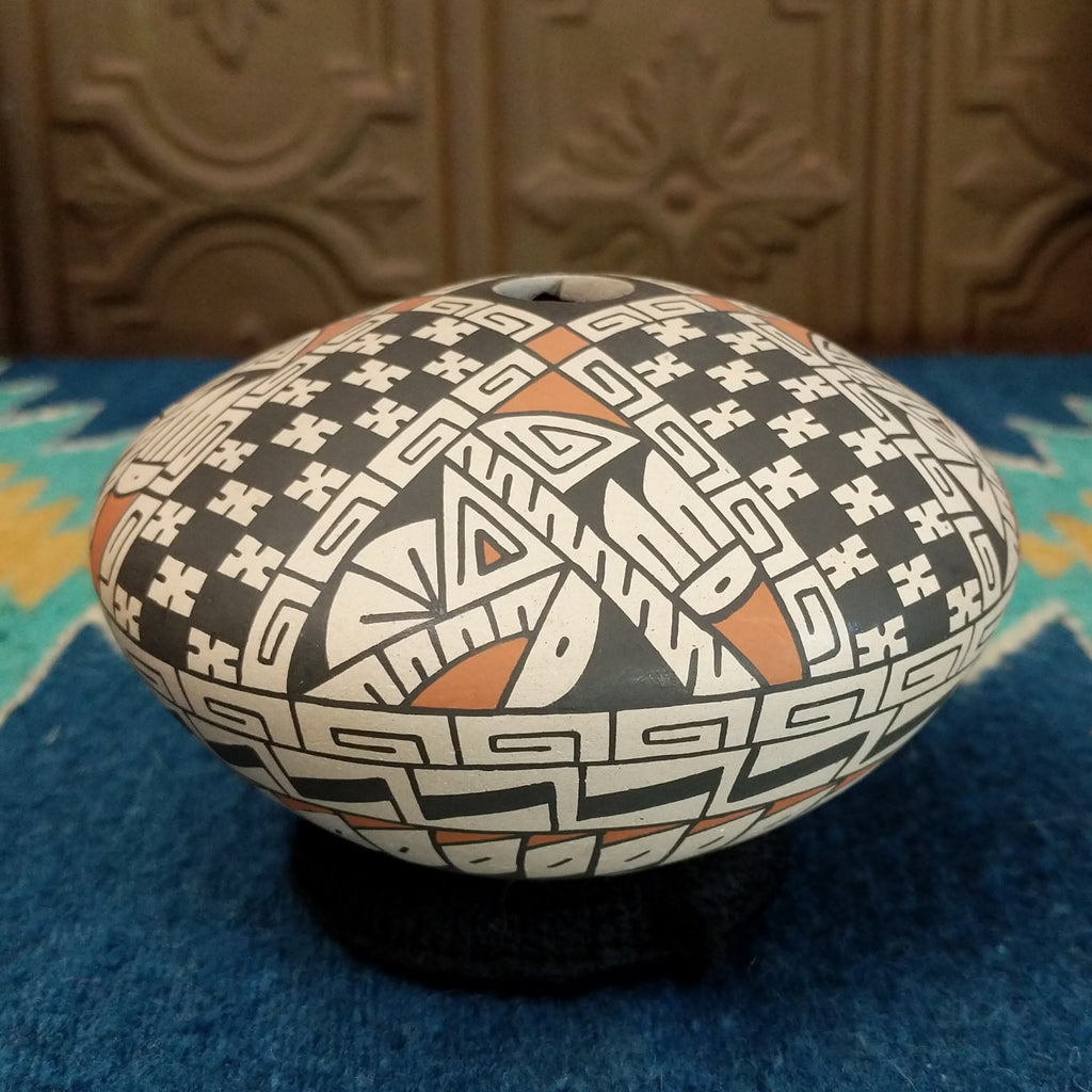 White clay seed pot painted in traditional colors.