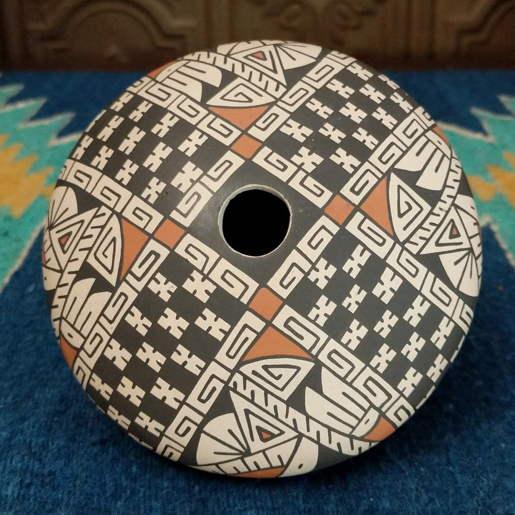 White clay seed pot painted in traditional colors.
