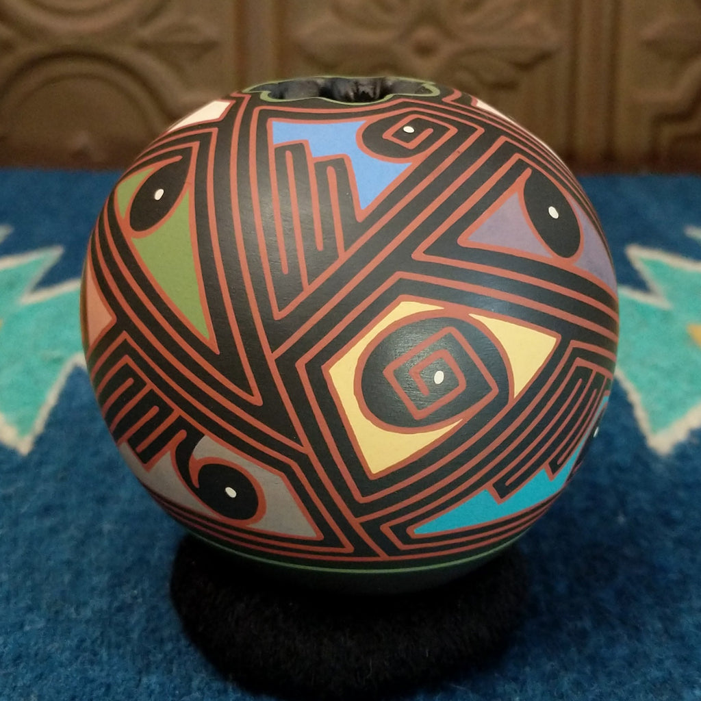 Round clay pottery with colorful and abstract designs.