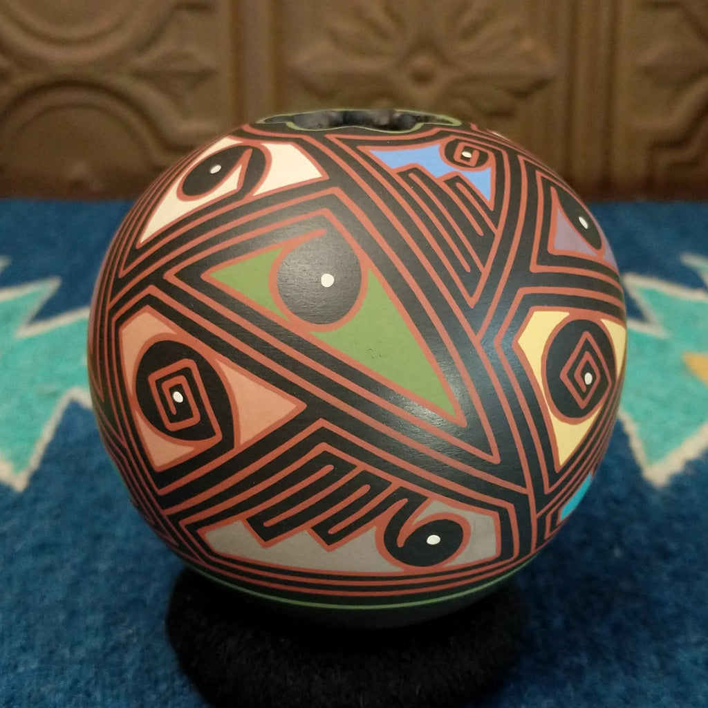 Round clay pottery with colorful and abstract designs.