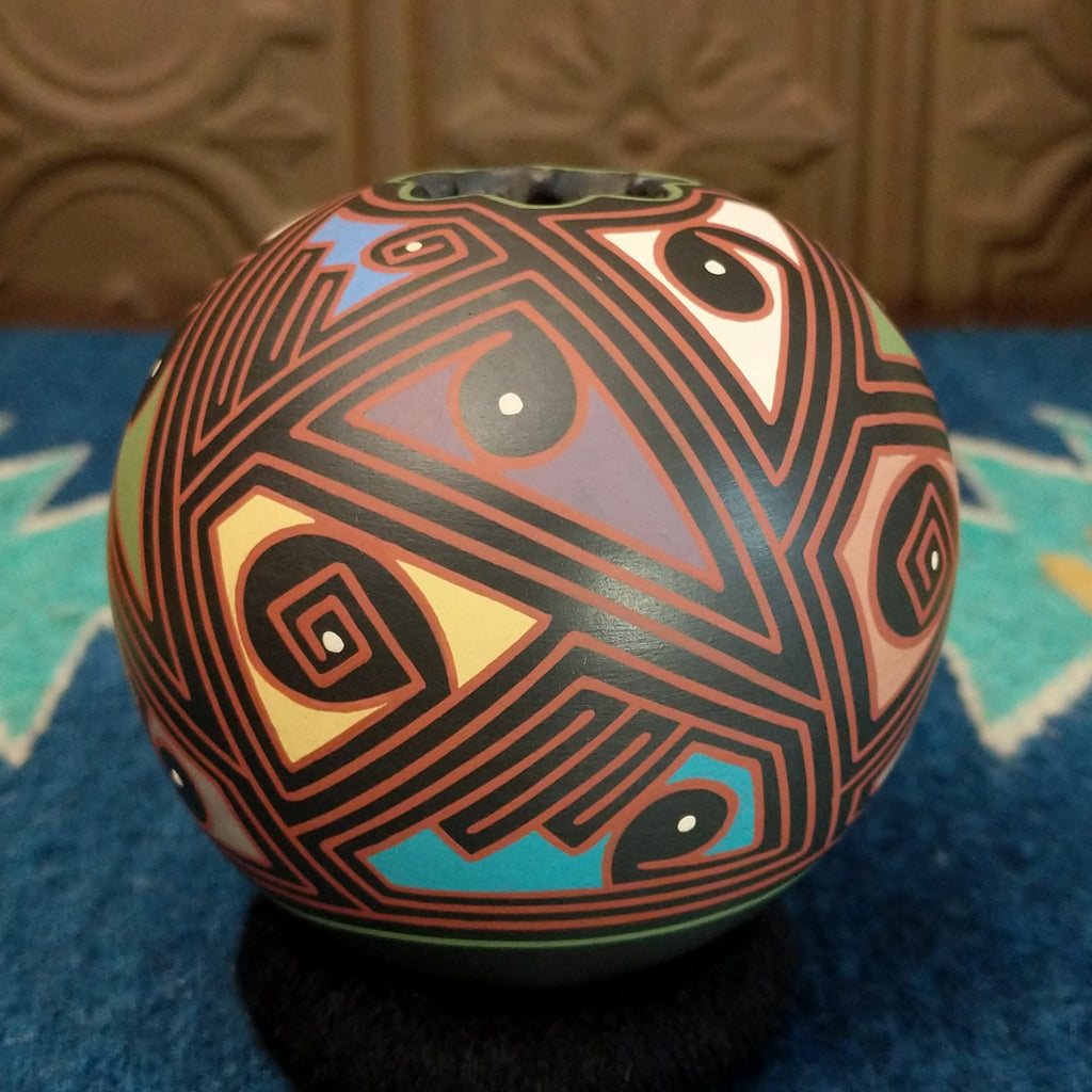 Round clay pottery with colorful and abstract designs.