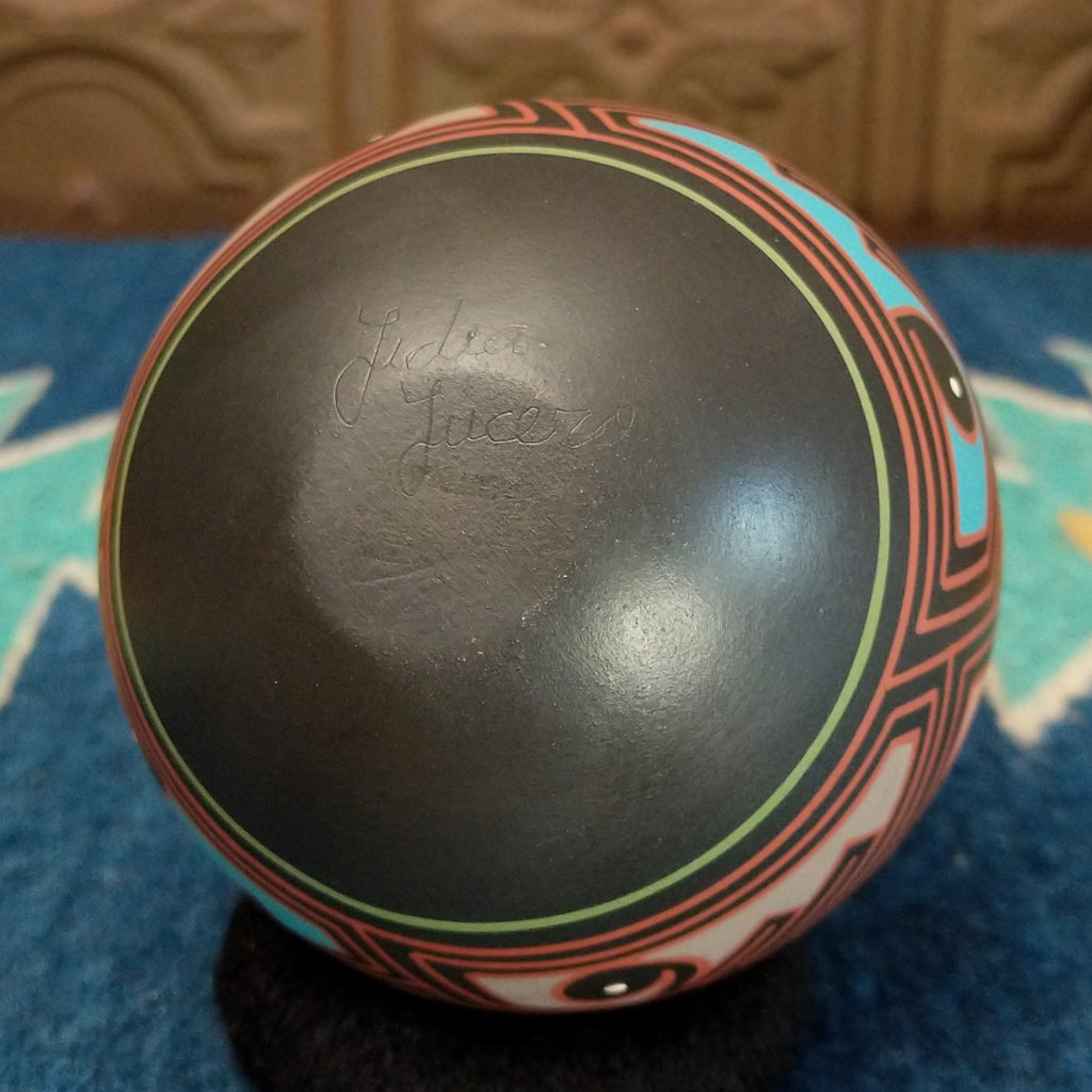 The underside features the artisan's signature.