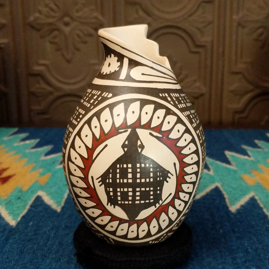 Clay pottery painted in traditional colors featuring geometric and turtle patterns, with a stepped lip.
