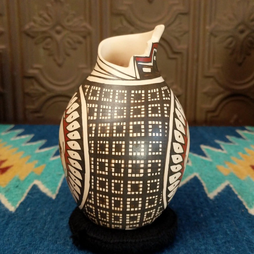 Clay pottery painted in traditional colors featuring geometric and turtle patterns, with a stepped lip.