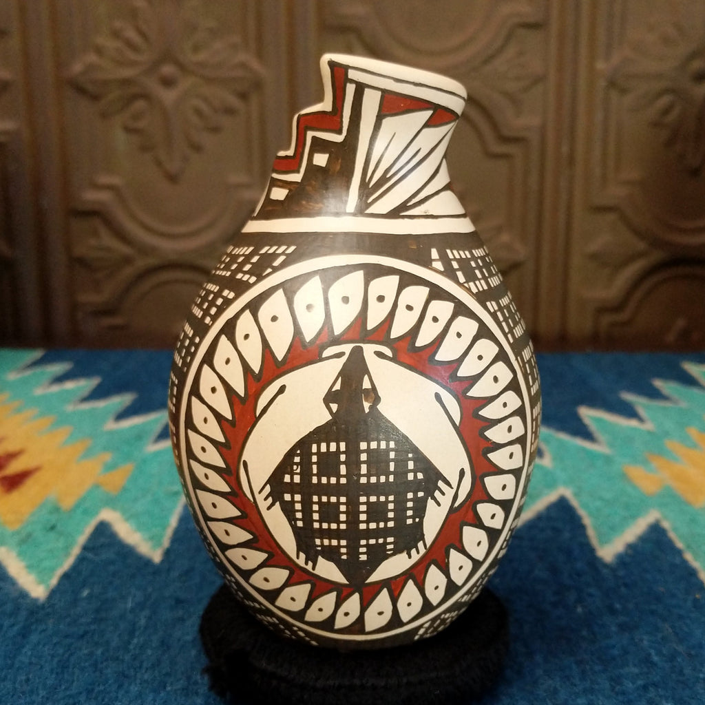 Clay pottery painted in traditional colors featuring geometric and turtle patterns, with a stepped lip.