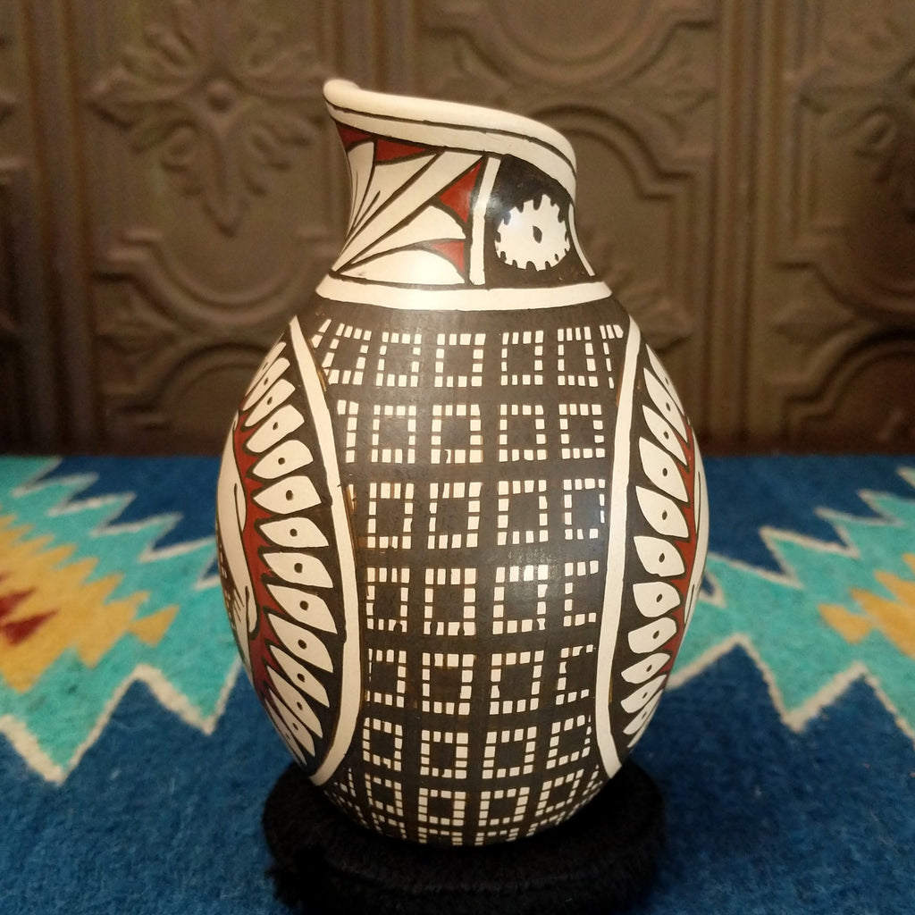 Clay pottery painted in traditional colors featuring geometric and turtle patterns, with a stepped lip.