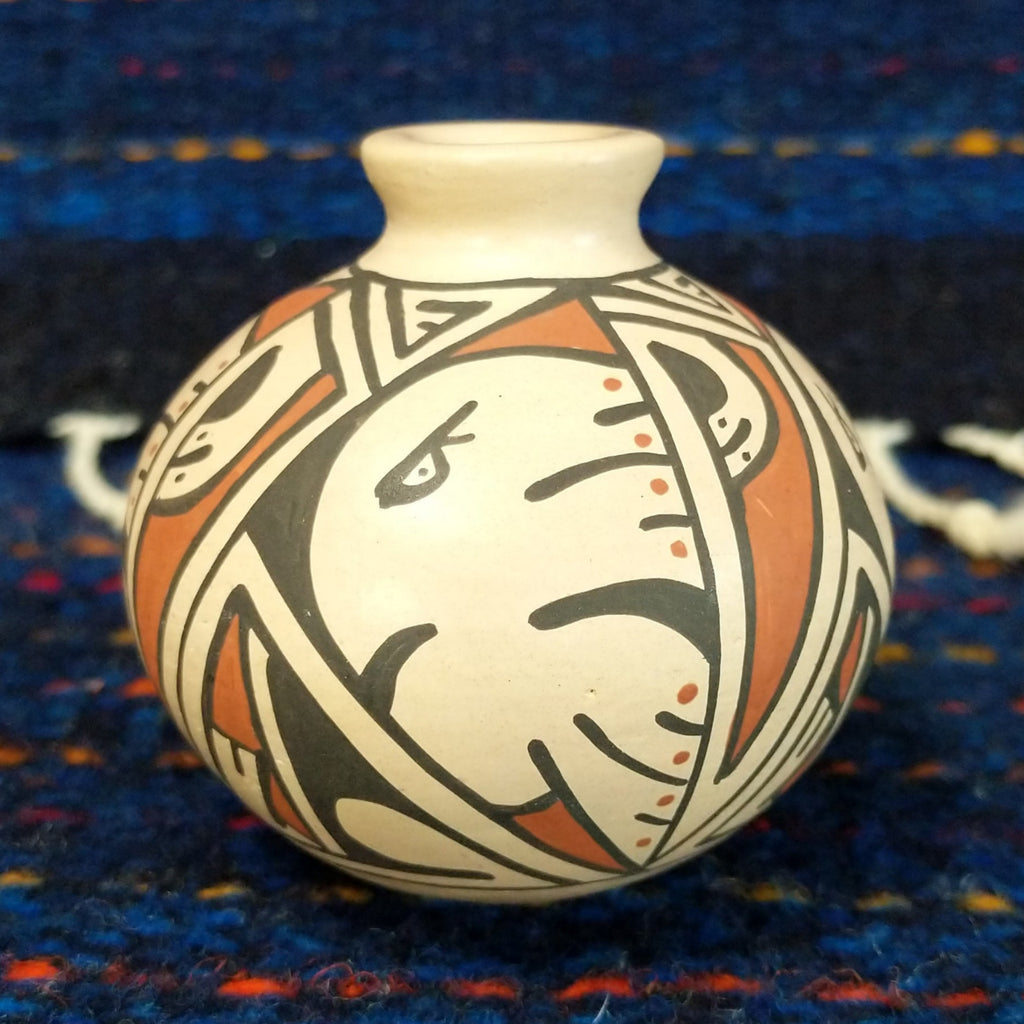 White clay body with a black and red, and a stylized Thunderbird design.