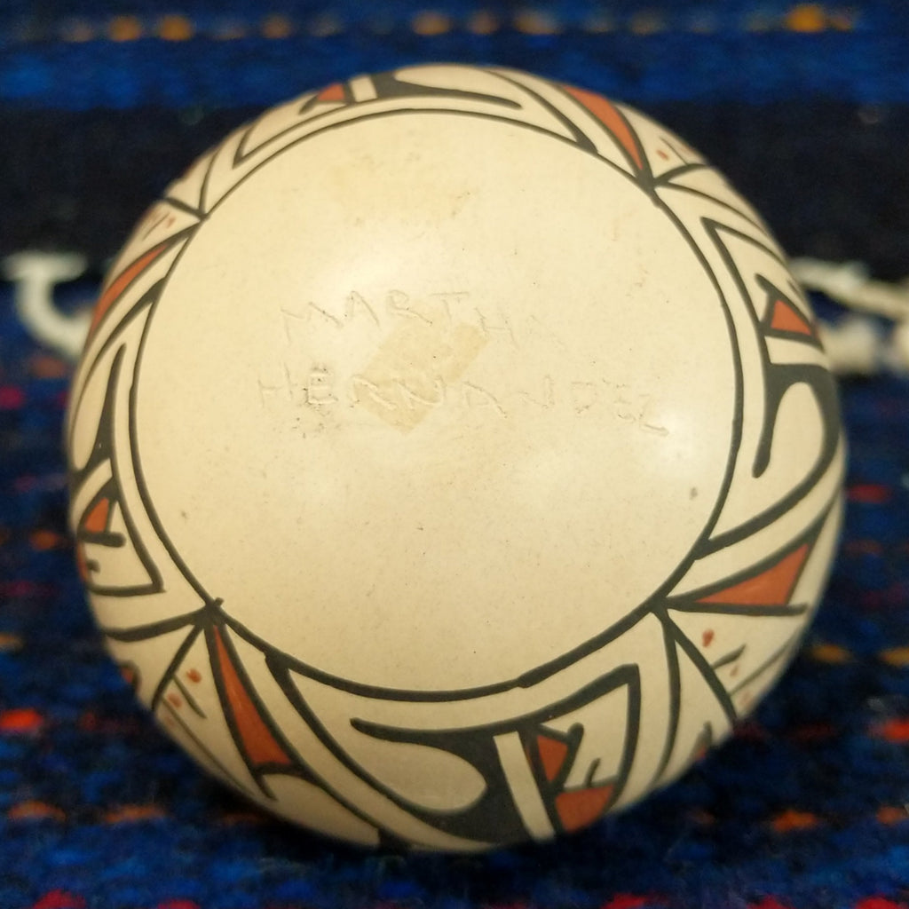 The artist's signature is etched into the base of the pot.