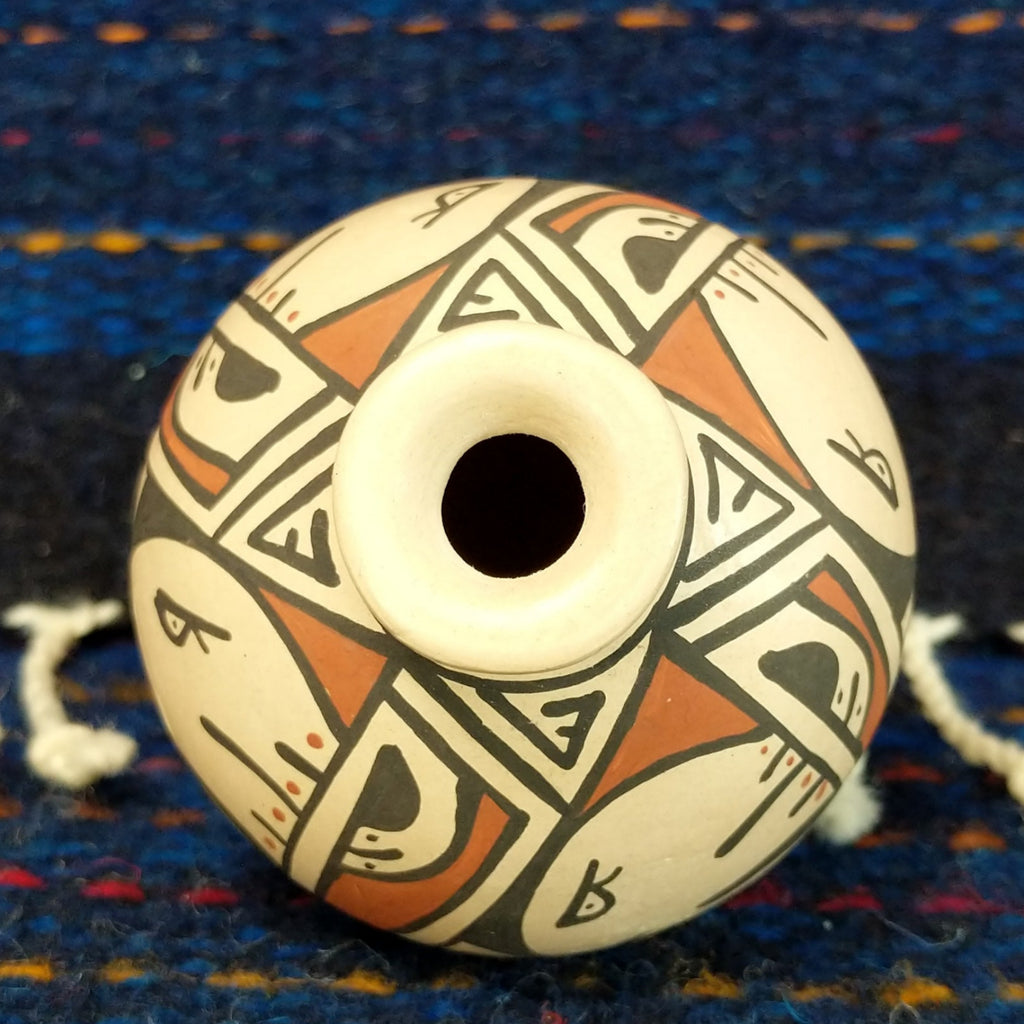 The top of the pot showcases the small opening and various geometric patterns.