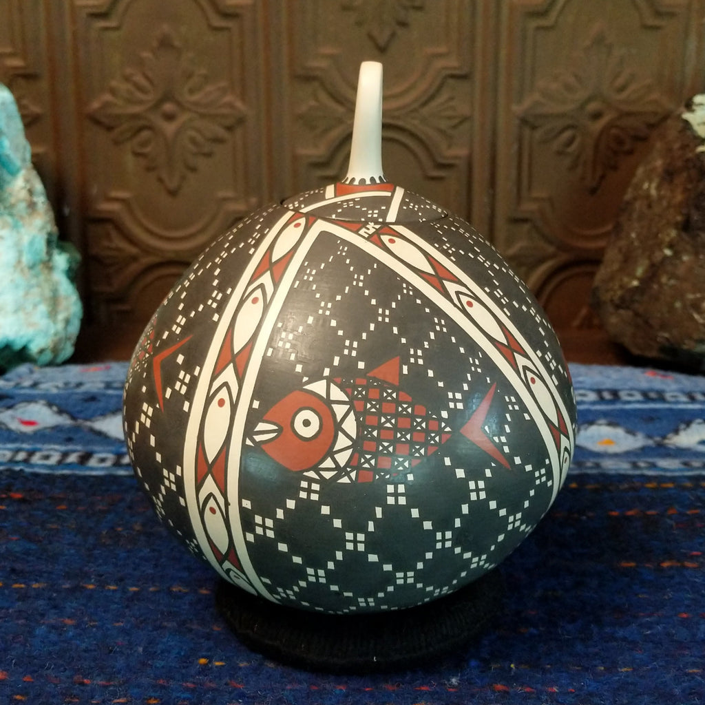 White clay base with black and red designs and fish motif.