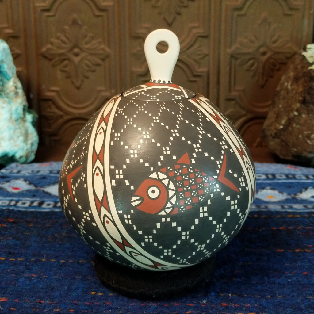 White clay base with black and red designs and fish motif.