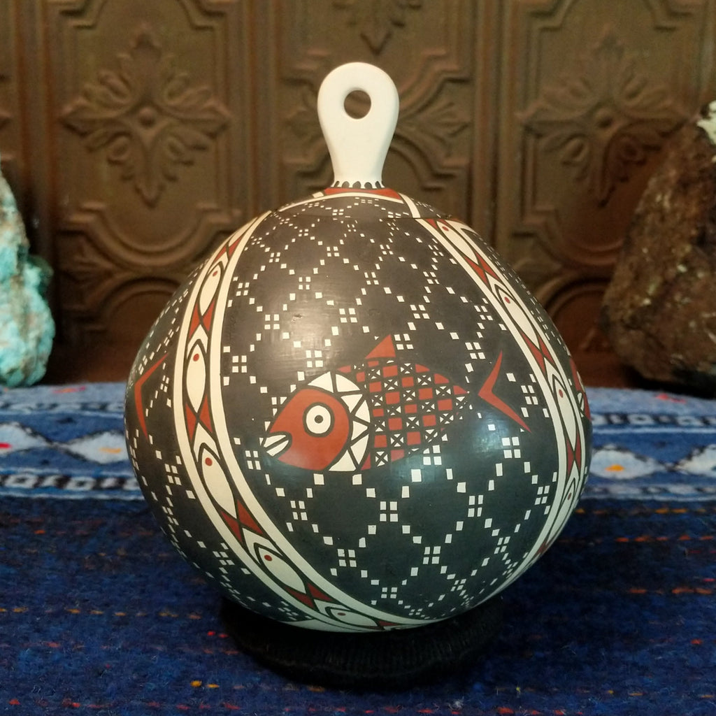 White clay base with black and red designs and fish motif.