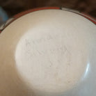 Close up of the artist's engraved signature.