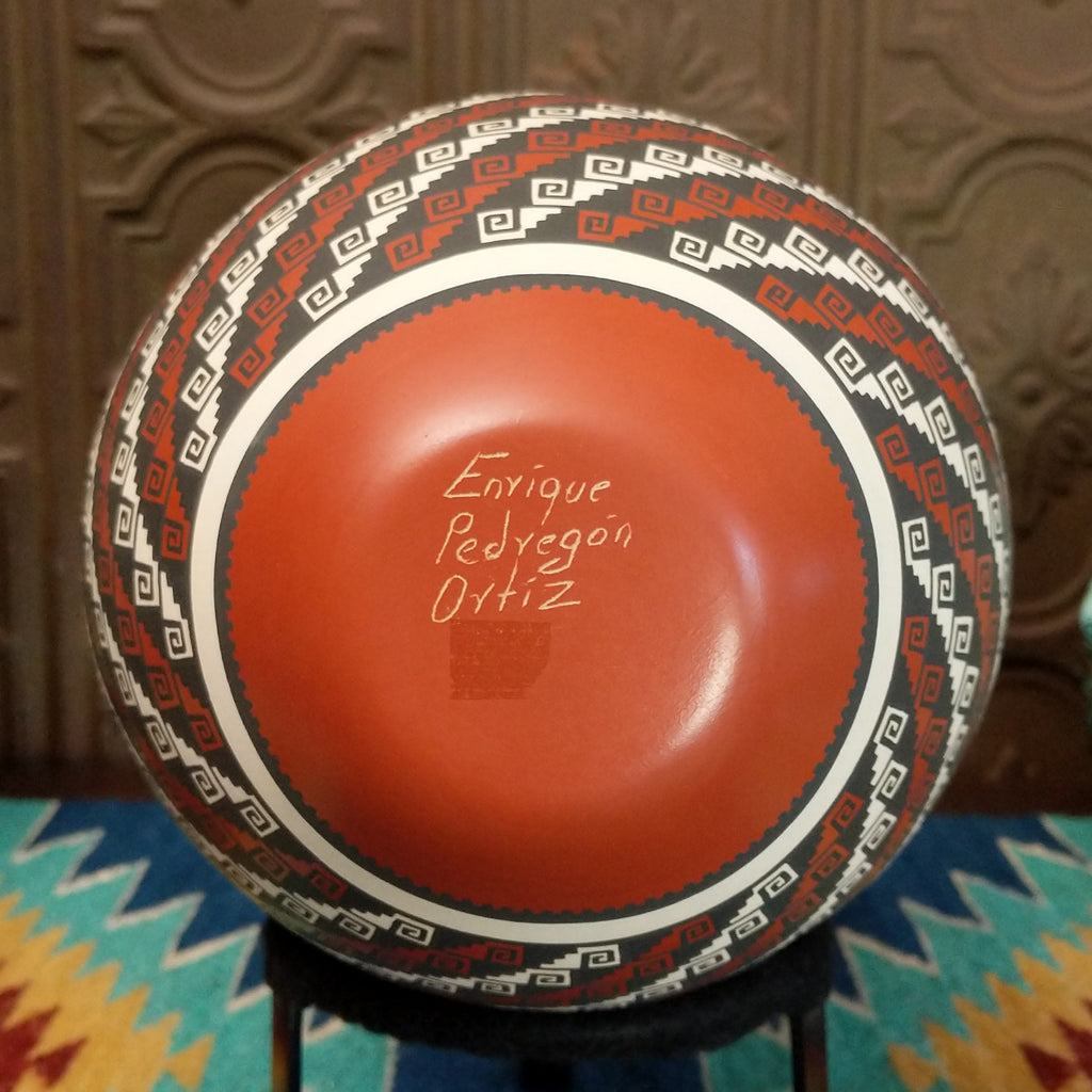 The underside features the artisan's signature.