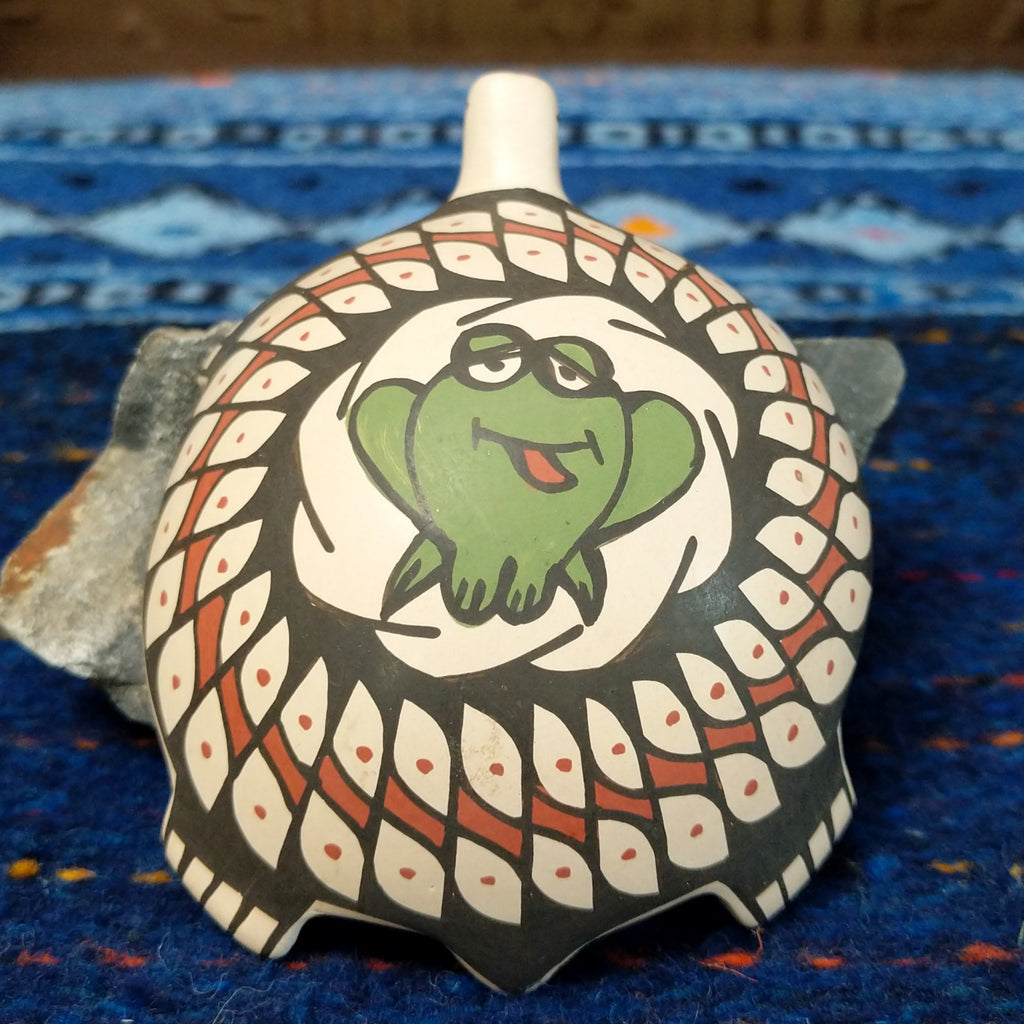 Green frog sticking its' tongue out on the top of the shell.