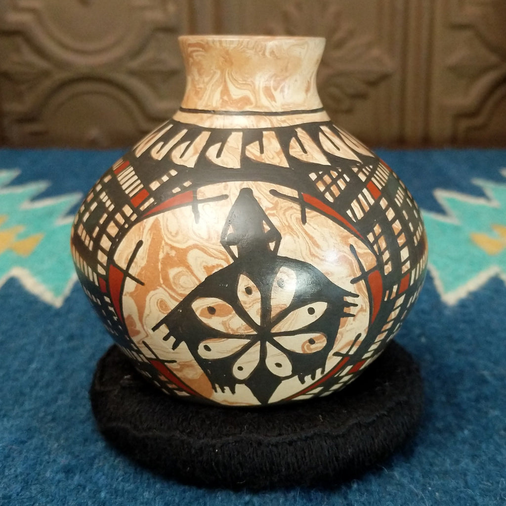 Marbled white clay with painted geometric and turtle designs in traditional colors.
