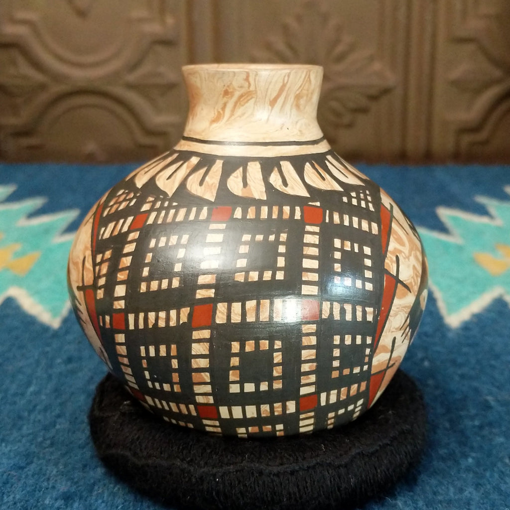 Marbled white clay with painted geometric and turtle designs in traditional colors.