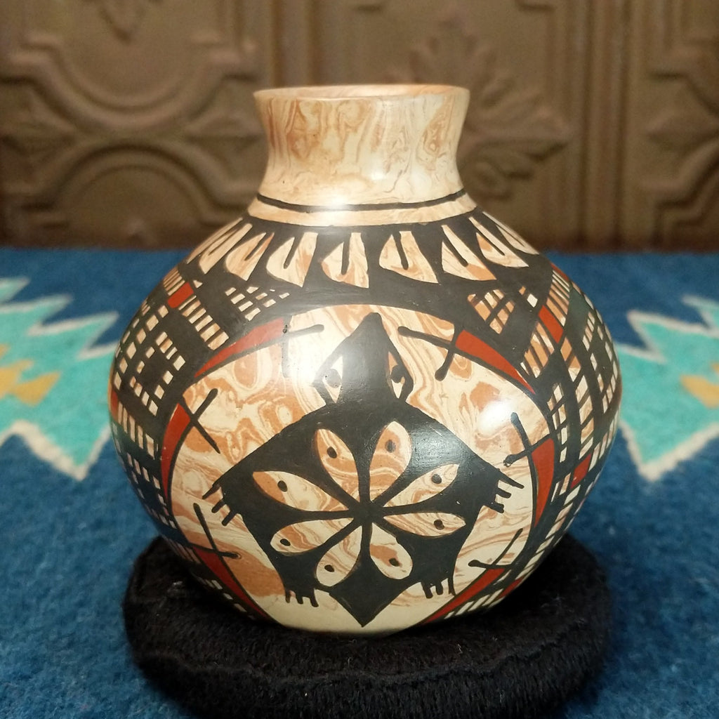 Marbled white clay with painted geometric and turtle designs in traditional colors.