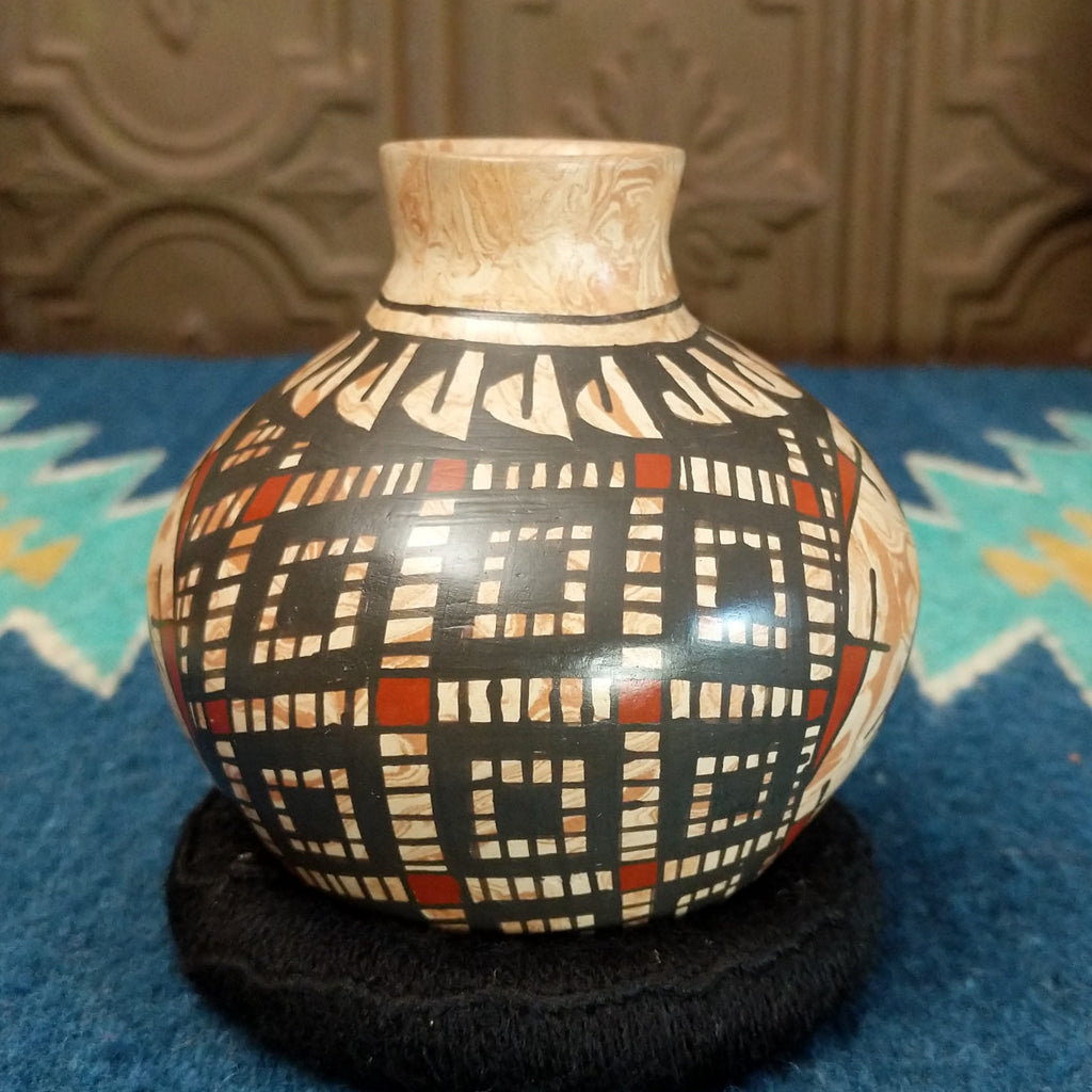 Marbled white clay with painted geometric and turtle designs in traditional colors.