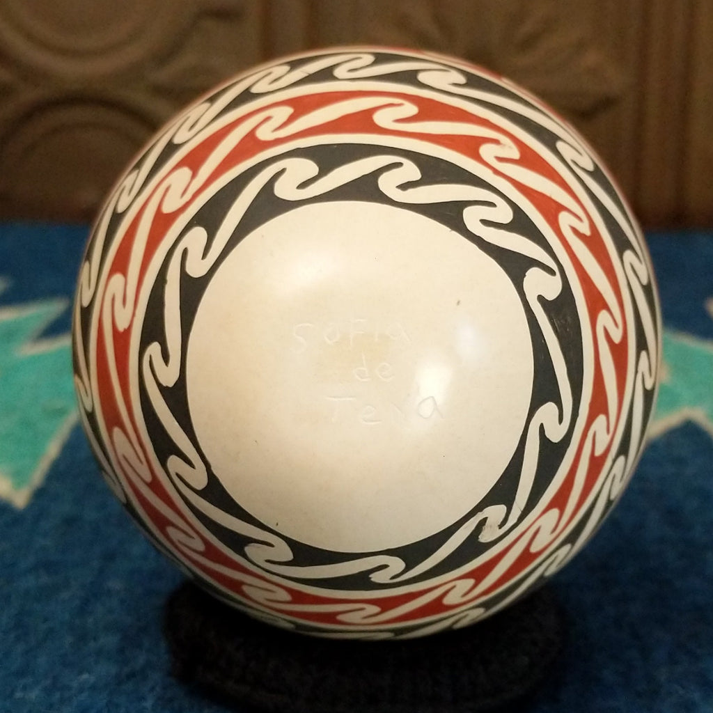 The underside of the pot features the artisan's signature.