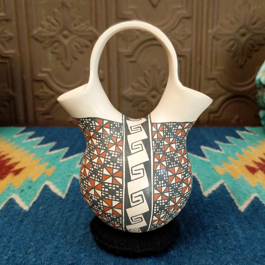 White clay wedding vase with traditionally colored geometric designs.
