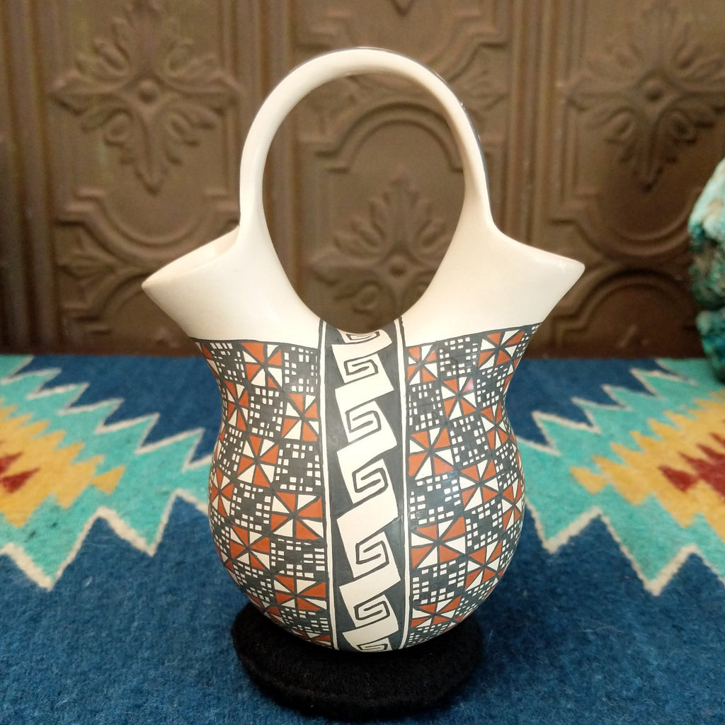 White clay wedding vase with traditionally colored geometric designs.